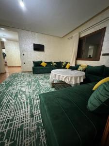 Derouaappartement spacieux的客厅配有绿色沙发和桌子