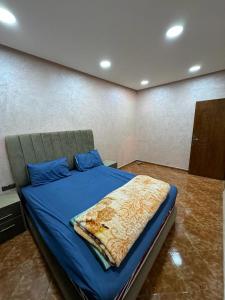 Derouaappartement spacieux的一间卧室配有一张带蓝色毯子的床