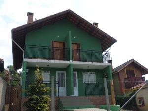 蒙特韦尔迪chales e aptos Carvalhos em monte verde的绿色房子的顶部设有阳台