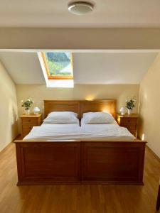 罗格坡曼戈唐Hotel Alpine的一间卧室设有一张大木床和窗户