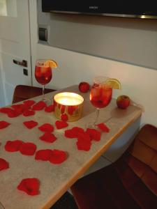 科沙林Zielony Zakątek z balkonem的两杯酒和一张带红花的桌子上的蜡烛