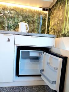 科沙林Zielony Zakątek z balkonem的厨房配有开放式冰箱,设有水槽