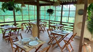IrandubaBioma EcoLodge的餐厅设有木桌、椅子和窗户。