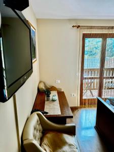 罗格坡曼戈唐Hotel Alpine的客厅配有沙发和墙上的电视