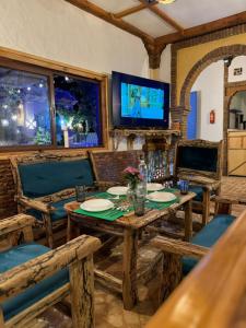 舍夫沙万alberegue Rustica的一间带桌椅和电视的用餐室