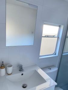 德布吉Holender Dębki的白色的浴室设有水槽和窗户。