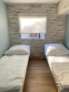 德布吉Holender Dębki的小型客房 - 带2张床和窗户