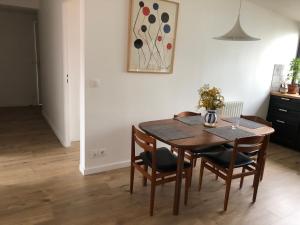 蒙特勒伊Cosy apartment in Montreuil near Paris center的一间带桌椅和绘画的用餐室