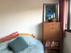 蒙特勒伊Cosy apartment in Montreuil near Paris center的一间卧室配有一张床和一张带照片的梳妆台