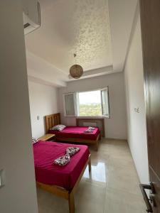 Hammamet SudMaison de vacances的客房设有两张床和窗户。