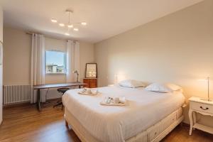 安格雷Beautiful T3 with large terrace - Anglet - Welkeys的卧室配有一张大白色的床和书桌
