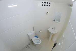 迪维诺波利斯VA Apart Hotel Savassi的白色的浴室设有卫生间和水槽。