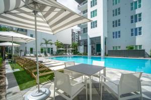 劳德代尔堡Sejur Fort Lauderdale的一个带桌椅和遮阳伞的游泳池