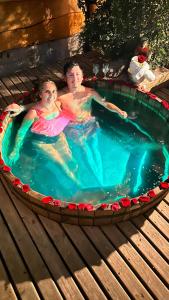 富特罗诺Cabañas Pewma Futrono的两人在游泳池的热水浴池中