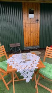 奥斯威斯Willowdene shepherds hut的一张木餐桌,上面有桌布