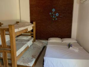 塔甘加Hostal Buena Vida的带三张双层床和砖墙的客房