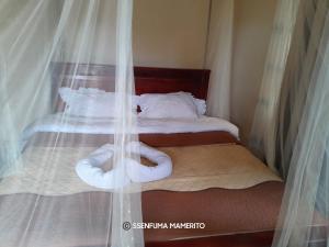 KalangalaPelican Resort Beach的一间卧室配有两张带白色床单的床