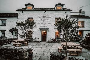 Bowland BridgeThe Hare & Hounds Inn的前面设有野餐桌的白色建筑