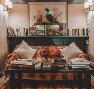 Bowland BridgeThe Hare & Hounds Inn的客厅配有带书籍和桌子的沙发
