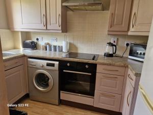 WhistonLanEnd House的厨房配有炉灶、洗衣机和烘干机