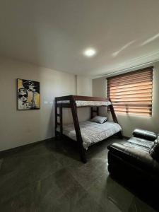 蒙特雷Lujoso departamento en Monterrey的客房设有两张双层床和一张沙发。