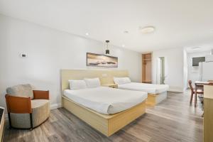 沃萨加比奇海滩萨迦度假酒店的一间卧室配有两张床、一张桌子和一把椅子