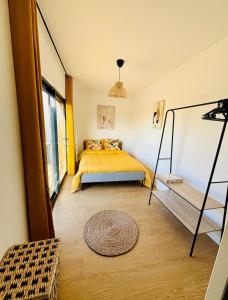奥登河畔的布雷特维尔Evasion tropicale的一间卧室设有黄色的床和窗户。