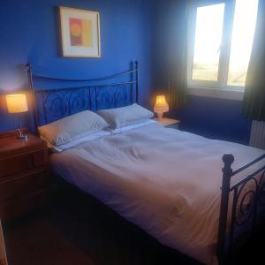 巴里瓦尼奇Comfortable detached 4 bedroomed holiday home的一间卧室配有一张带白色床单和两盏灯的大床