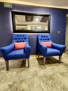 托雷翁Hotel Roque的两个蓝色的椅子和镜子