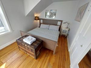 汉密尔顿Doucet Guesthouse的铺有木地板的客房内的一张小床