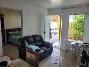 马塞约CASA JARDIM PINHEIROS的一间带椅子的客厅和一间卧室