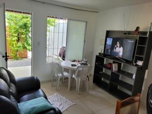 马塞约CASA JARDIM PINHEIROS的一间带电视和餐桌的客厅