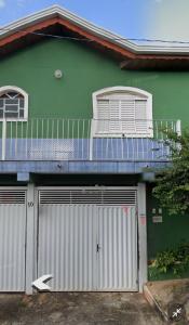 布拉干萨-保利斯塔Pousada Malu的绿色房子,设有两个车库门和阳台