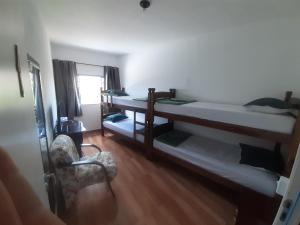 布拉干萨-保利斯塔Pousada Malu的带两张双层床和椅子的房间