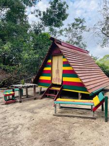ZanderijLand of Promise - Reggae Escape的板凳顶上有屋顶的小房子