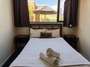 布里斯班HQ城市背包客旅馆的一间卧室配有带毛巾的床