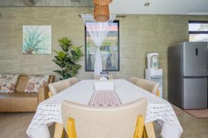 MaribagoISLA VILLA 2 Luxury Pool Villa near beach with karaoke video games barbecue的用餐室配有桌椅和冰箱