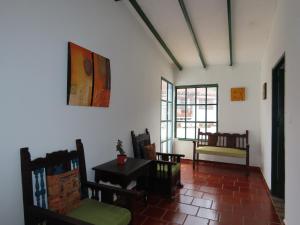 莱瓦镇Celeste Villa de Leyva的配有椅子和桌子的房间,窗户