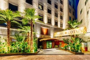 冈山Hotel Lotus Okayama Adult Only的一座楼前有棕榈树的酒店