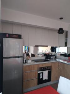 普孔Departamento con exelente ubicacion的厨房配有白色橱柜和不锈钢冰箱