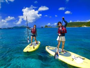 座间味村Marine Lodge Umigoya - Vacation STAY 23086v的两个女孩站在水中的桨板上