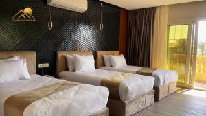 开罗Golden Pyramids Sunrise Hotel的酒店客房设有两张床和窗户。