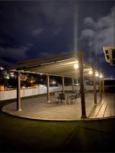 特古西加尔巴Condo in the heart of Honduras with an amazing view!的露台上,屋顶上在晚上摆放着桌椅