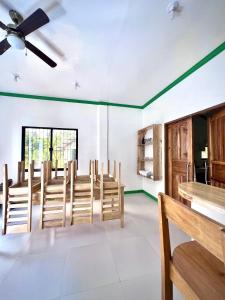 PilarNOGS Homestay, near Magpupungko, Siargao Island Surfings Spots的用餐室配有木椅和吊扇