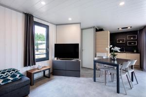 盖朗德Les Cottages de La Baule : Chalet de standing 7 personnes - Piscine的客厅配有桌子和电视