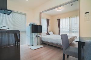 福冈Hotel Star Residence - 無人ホテル的一间卧室配有一张床、一张桌子和一台电视