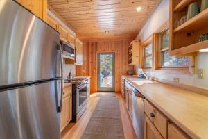 玛瑙湾Spacious, Central, & Cozy Cabin Near Lake & Trails的厨房配有不锈钢冰箱和木制橱柜