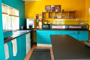 圣吉尔莱班依兰酒店的厨房设有蓝色橱柜和黄色的墙壁
