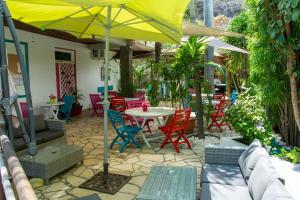 圣吉尔莱班依兰酒店的庭院配有桌椅和遮阳伞。