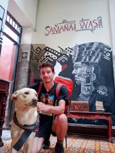 利马Samanai Wasi Hostel的商店前有狗的人